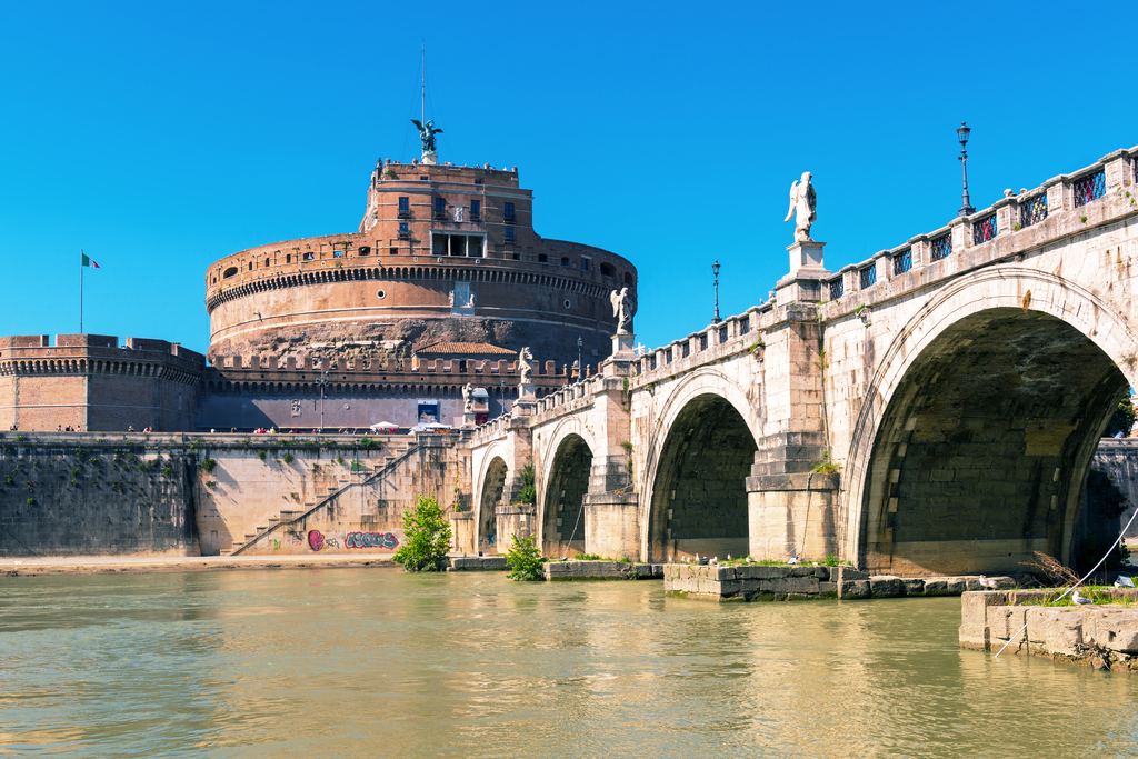 The cylindrical drum of Castel Sant'Angelo seen from the bank of the Tiber, an arch of the bridge to one side
