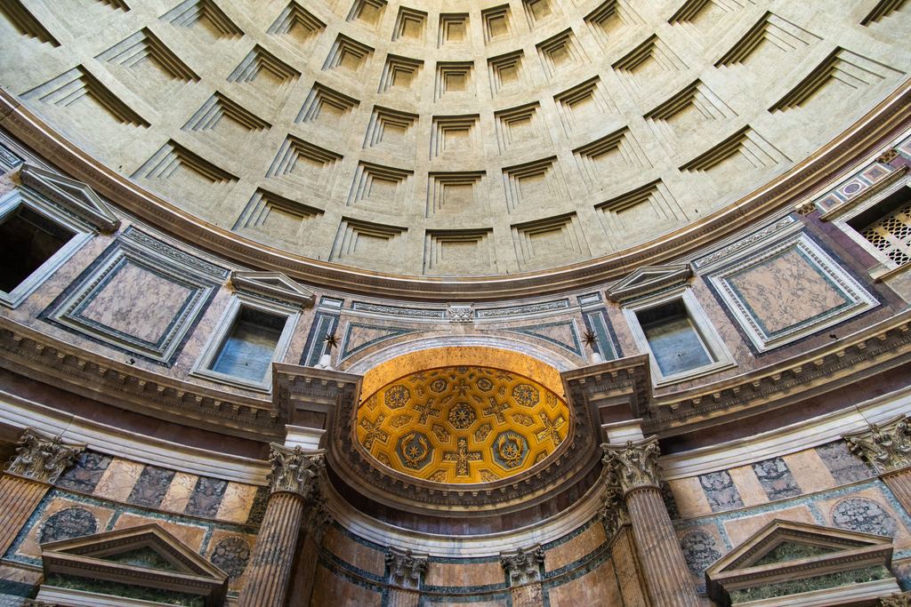 The coffered dome of the Pantheon seen from the floor, with the gilded apse and the coloured marble of the drum below