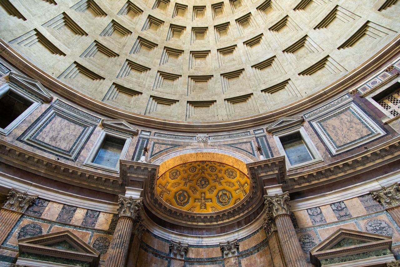 The coffered dome of the Pantheon seen from the floor, with the gilded apse and the coloured marble of the drum below