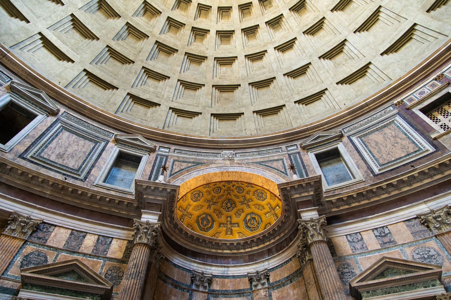 The Pantheon interior: the coffered dome, the gilded apse and the coloured marble of the drum