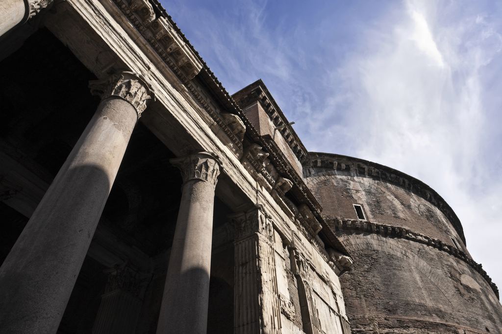Two of the Pantheon's grey granite column shafts seen from the base looking up, with the brick rotunda beyond