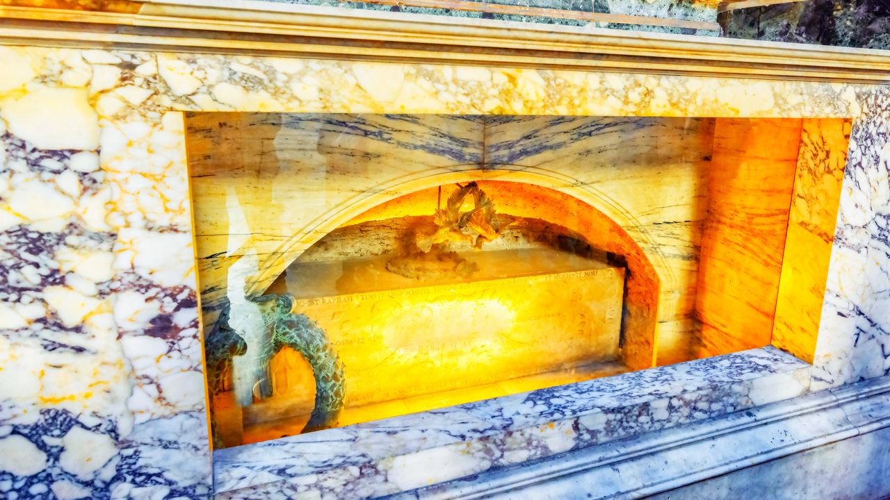 The ancient marble sarcophagus of Raphael's tomb inside the Pantheon, set in an aedicule of coloured marble