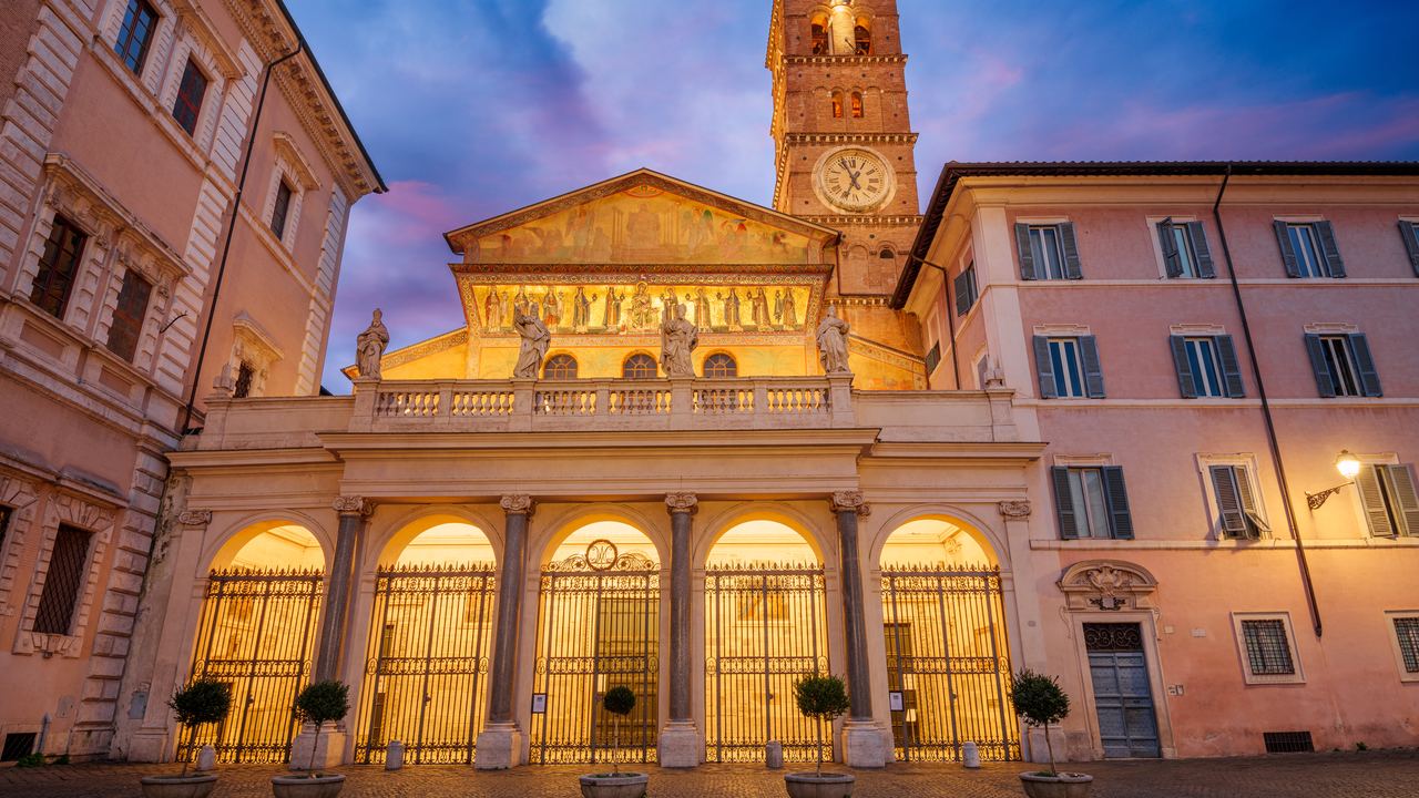 The mosaic facade of Santa Maria in Trastevere lit at dusk