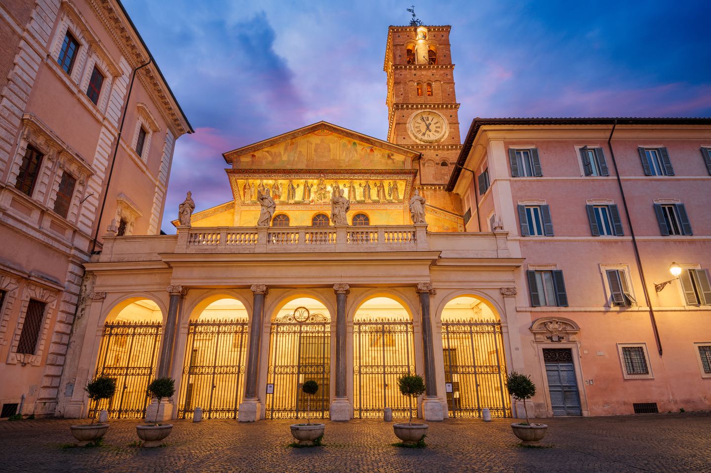 The mosaic facade of Santa Maria in Trastevere lit at dusk