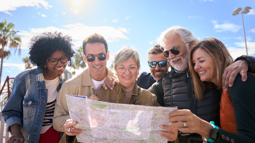 A small group of travellers standing together around an open paper map