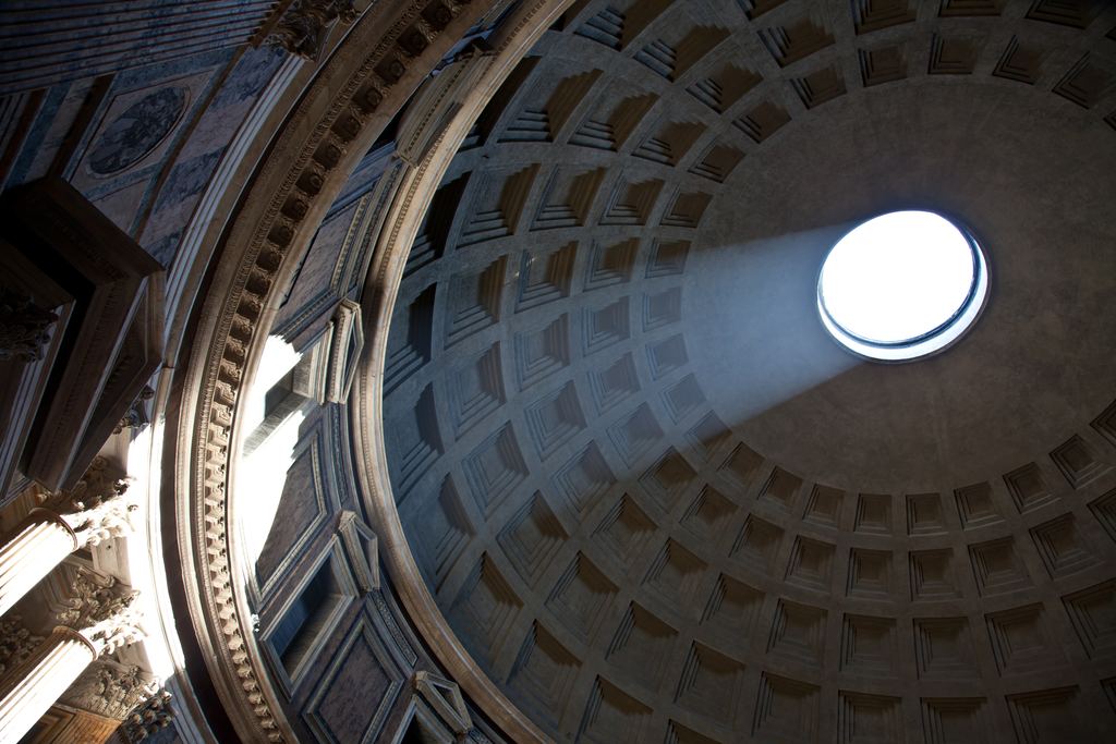 A solid shaft of sunlight falling through the Pantheon's oculus and crossing the dark interior