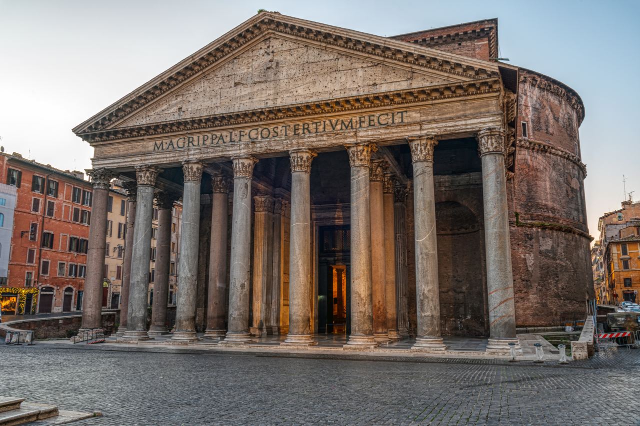 The front of the Pantheon in Rome in early morning light, the cobbled square in front of it completely empty