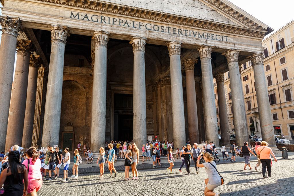 The Pantheon's inscription at full width above a crowd gathered in Piazza della Rotonda