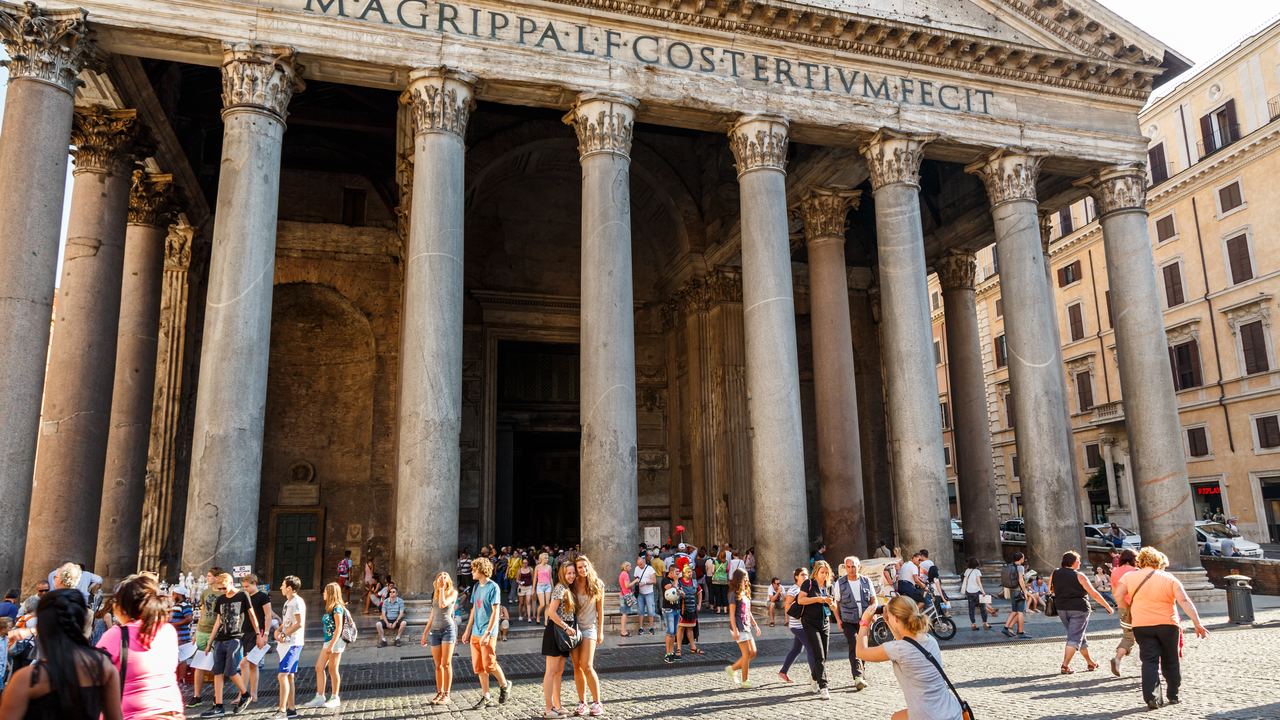 The Pantheon's inscription at full width above a crowd gathered in Piazza della Rotonda