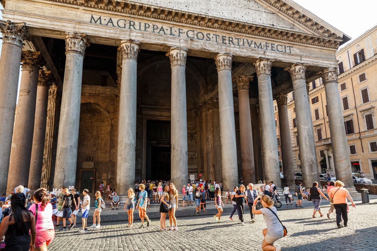 The Pantheon's inscription at full width above a crowd gathered in Piazza della Rotonda